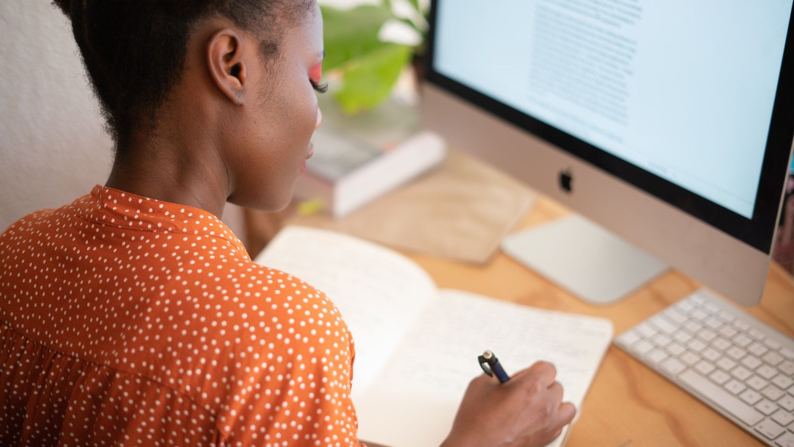 Photo - Young woman working on paper and on a computer