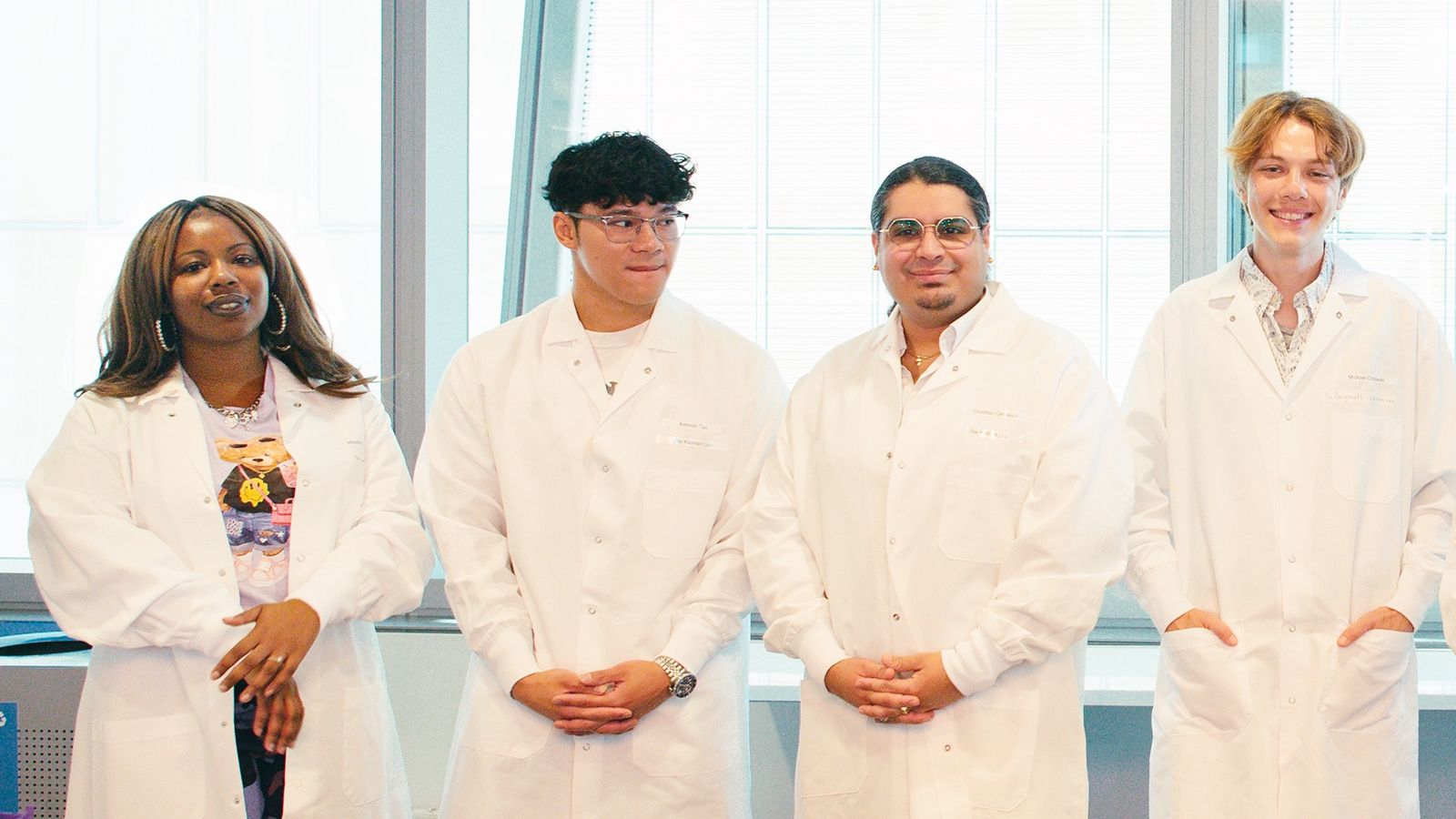 4 people in lab coats at a science event