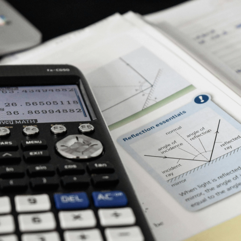 a close up of scientific calculator and physics textbook