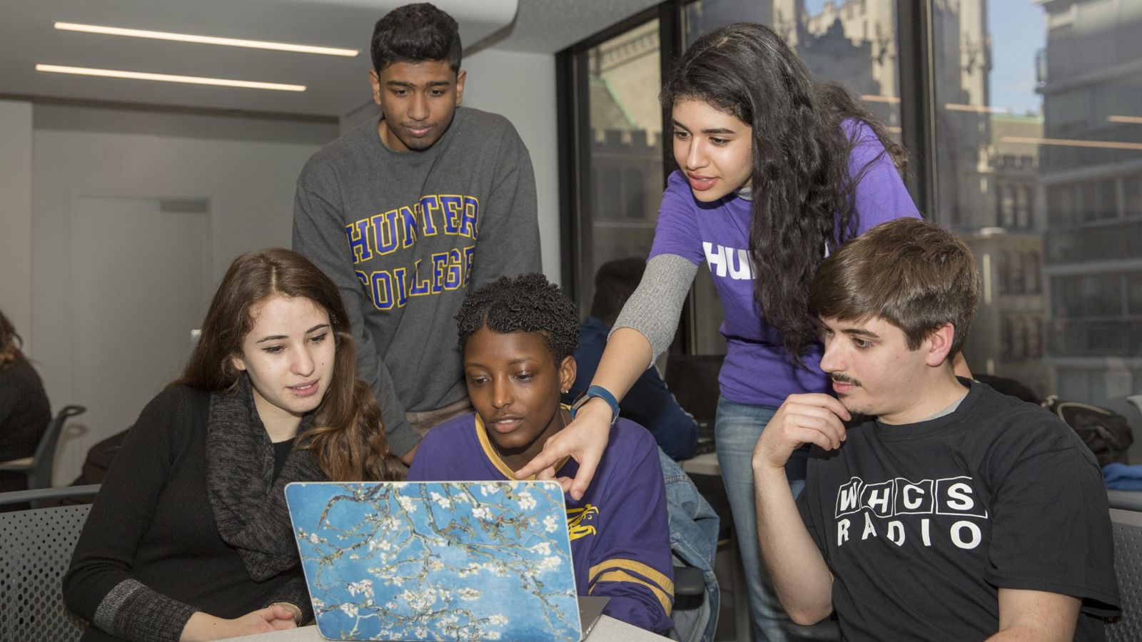 Students gathered around a laptop