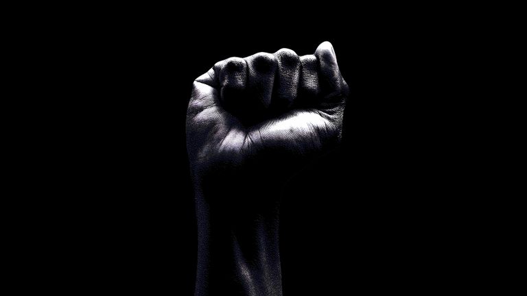 raised fist on black background.
