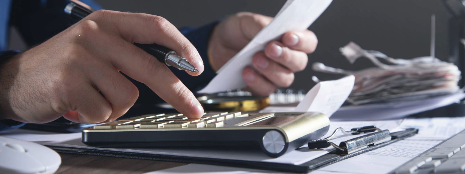 Person using a calculator while holding paper.