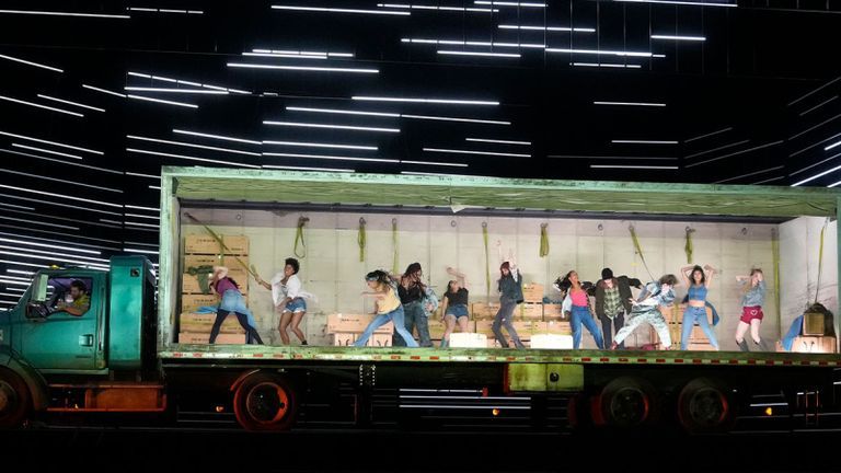 Performers dancing in the back of a truck on stage.