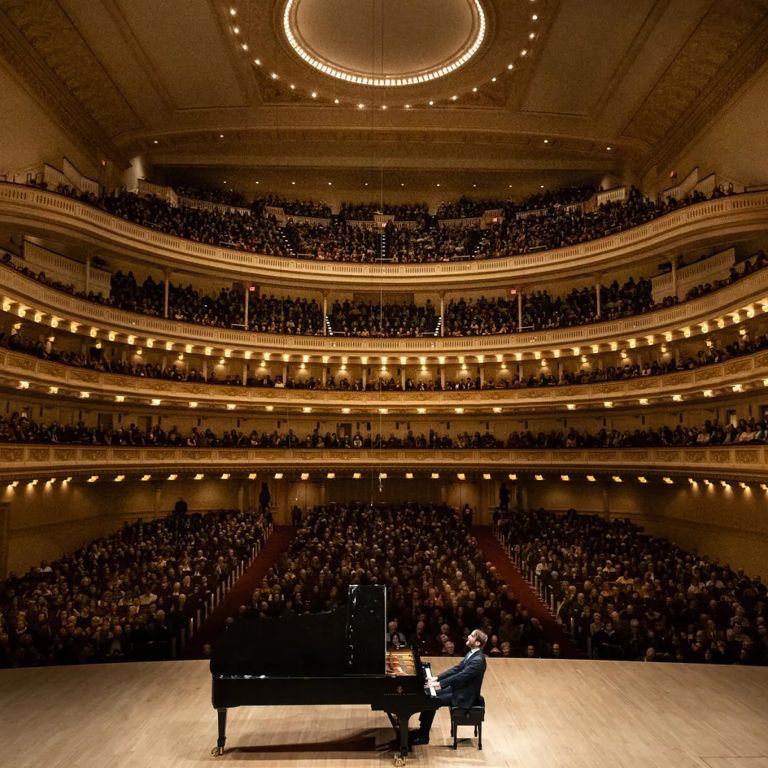 Pianists performs for audience at Carnegie Hall.