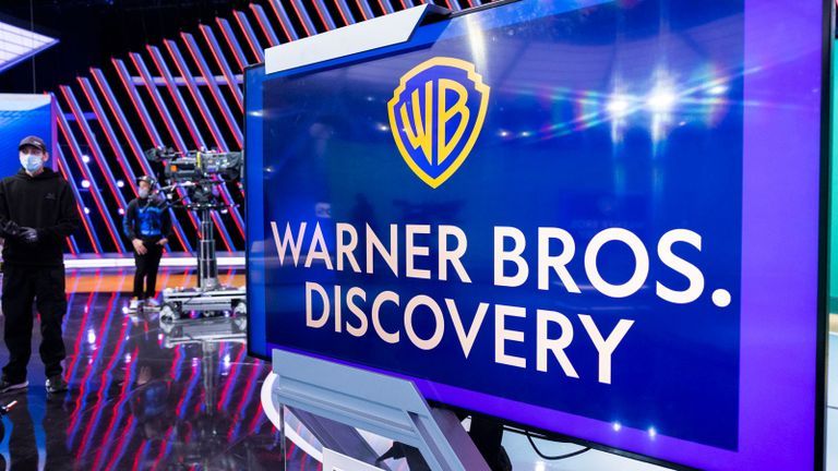 Photo - Warner Bros Discovery logo on set with staff and camera on a dolly.