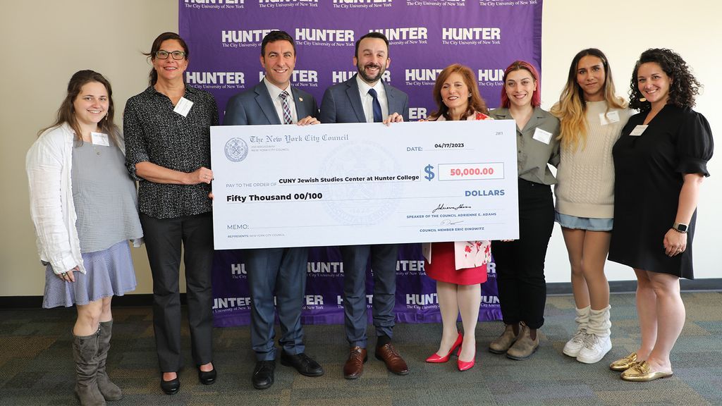 The council members present the check to Hunter College President Jennifer J. Raab (fourth from right), Professor Leah Garrett (second from left), and students.