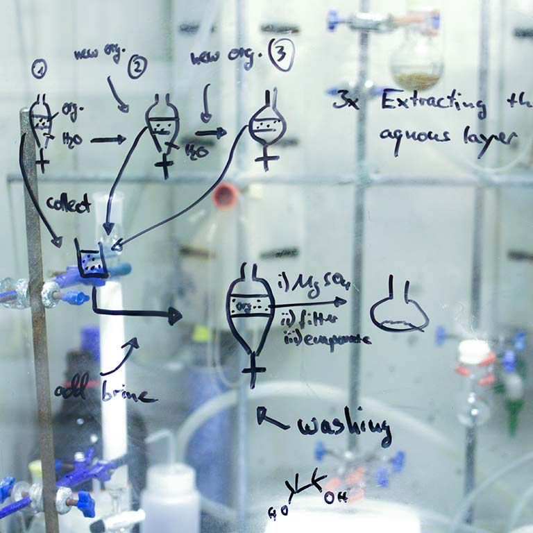 lab notes written on glass panel in lab setting