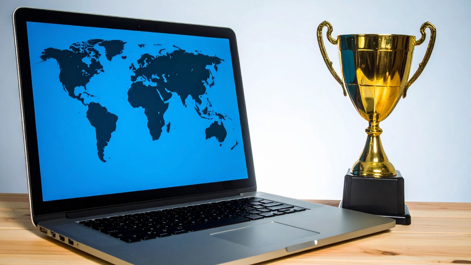 Trophy next to a computer screen displaying a world map.