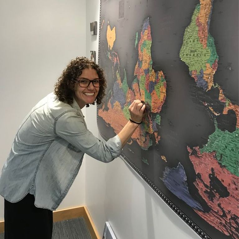 A person pointing at the world map