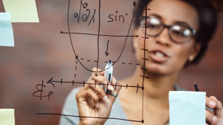 person solving math equations on glassboard