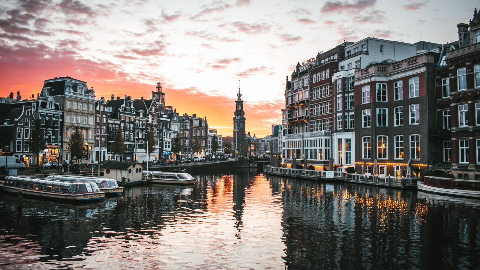 Photo of river reflecting the sunset and skyline of Amsterdam