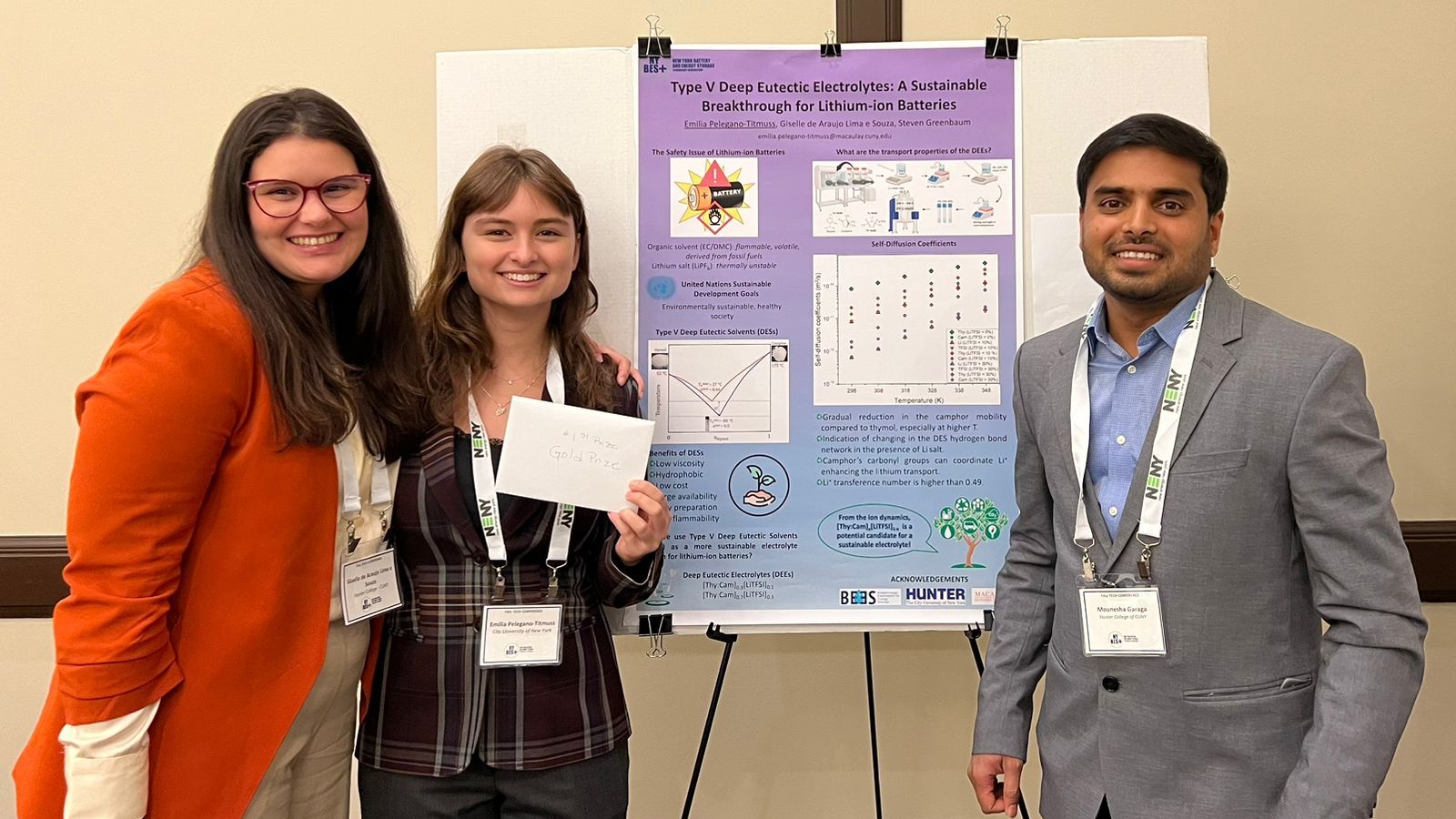 Emilia Pelegano-Titmuss, poses with her poster flanked by Research Associates Dr. Giselle Araujo and Dr. Mounesha Garaga.