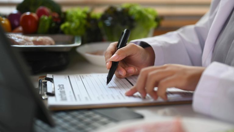 Person signing a form in the kitchen.