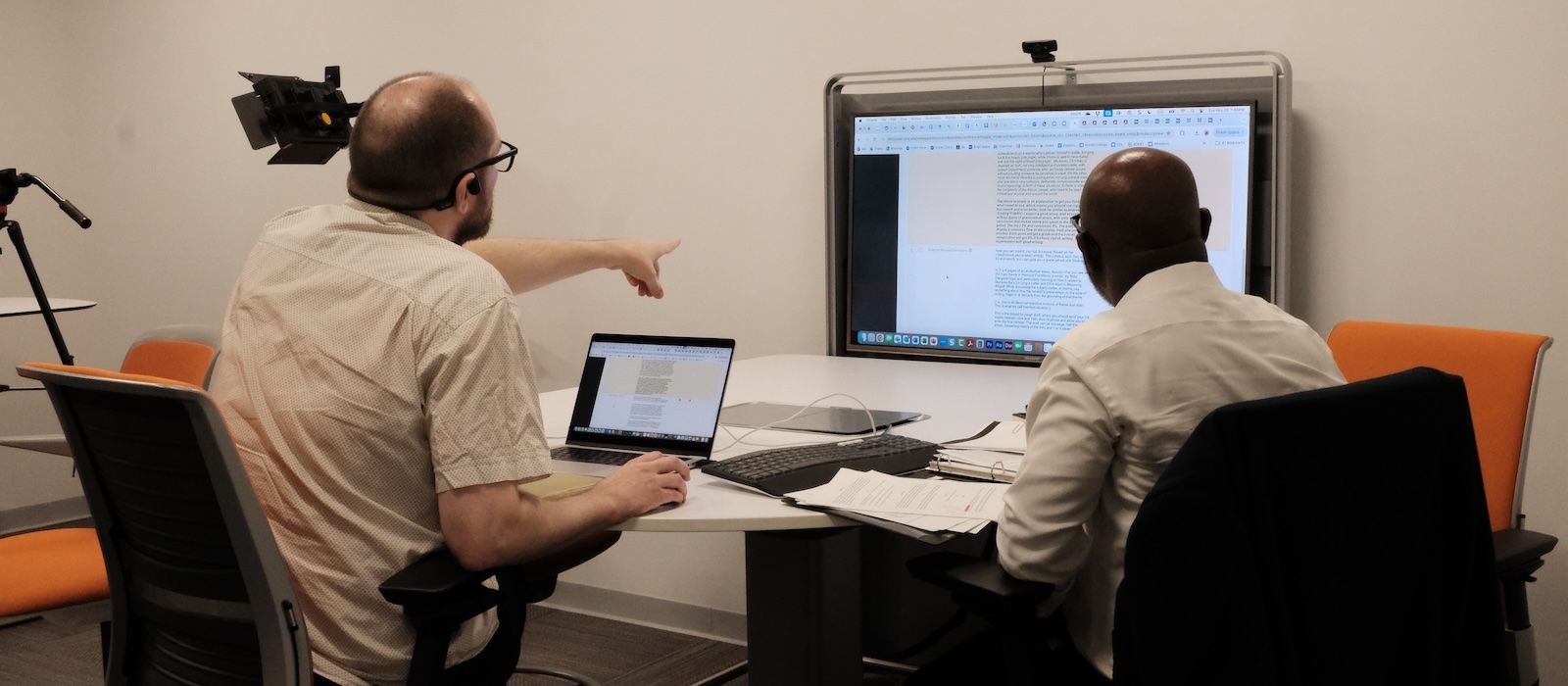 A faculty member and instructional designer sit and work on an online course together