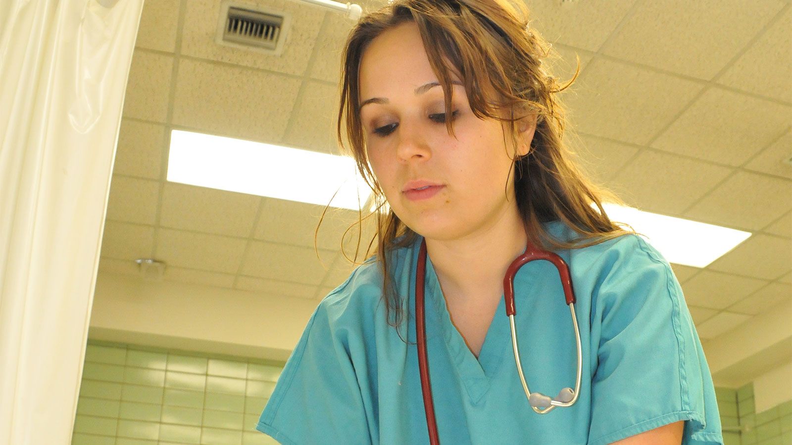hunter nursing student wearing scrubs and stethoscope in lab