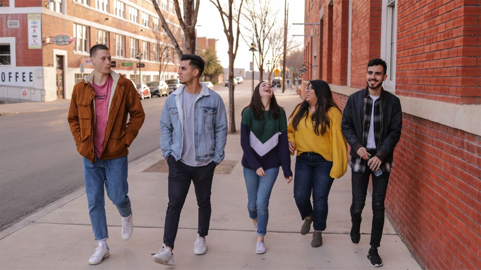 Photo - A group of students walking and chatting on a city street.