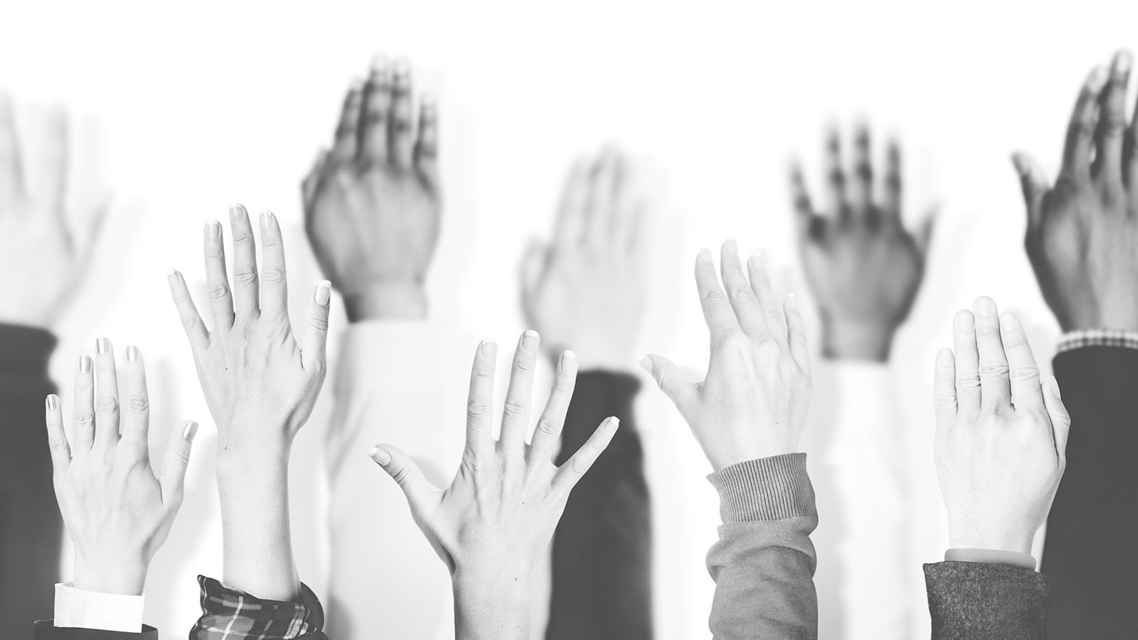 black and white image of raised hands.