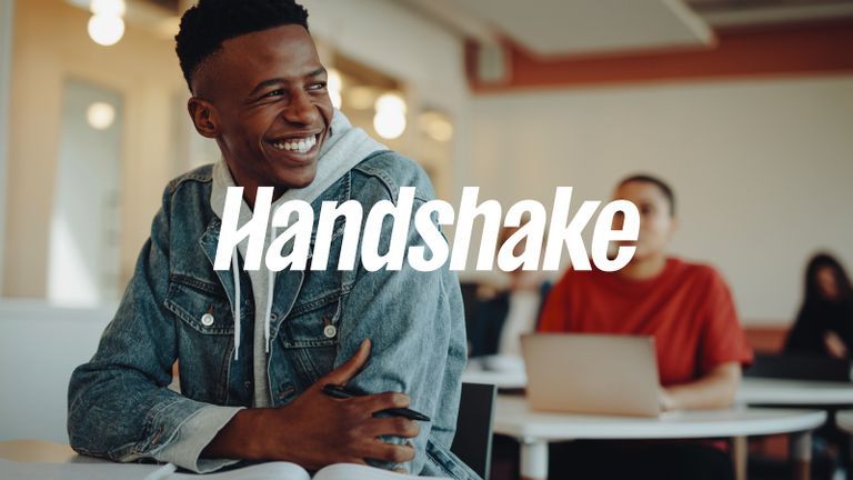 Photo - Young man leaning forward and smiling behind Handshake logo