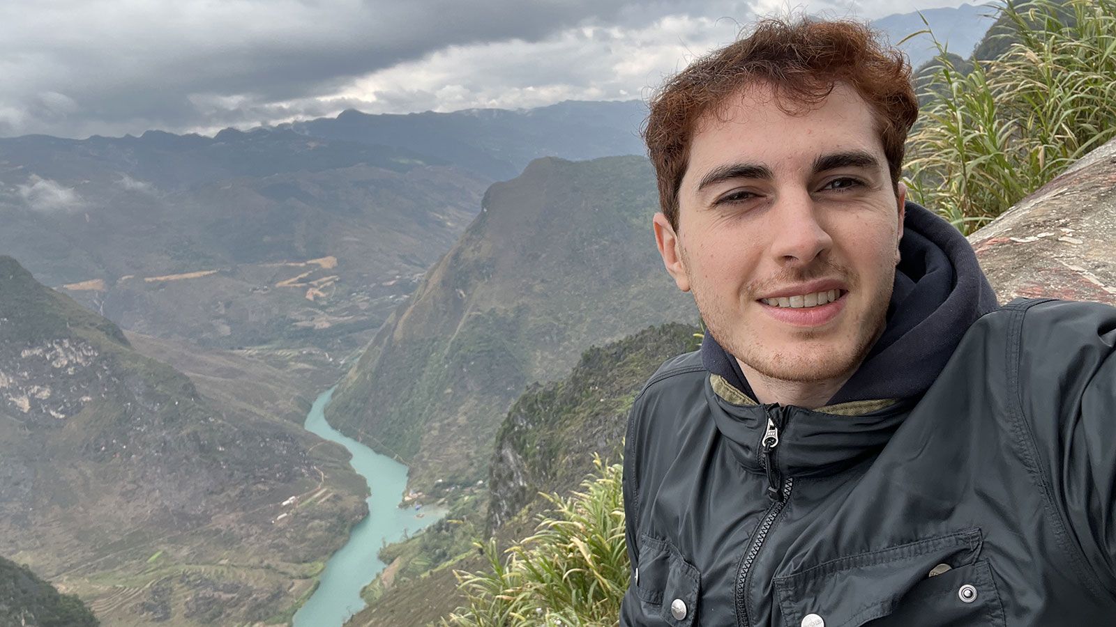 hunter student abroad with background of mountains with a river