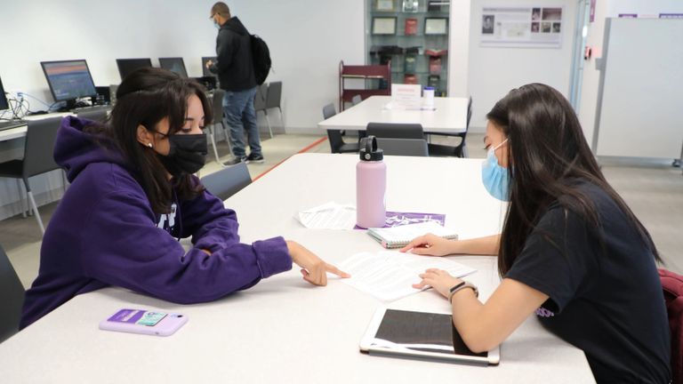 Two hunter students checking paperwork.