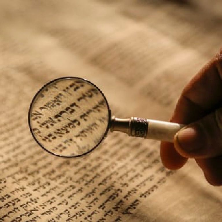 open hebrew book and magnifying glass