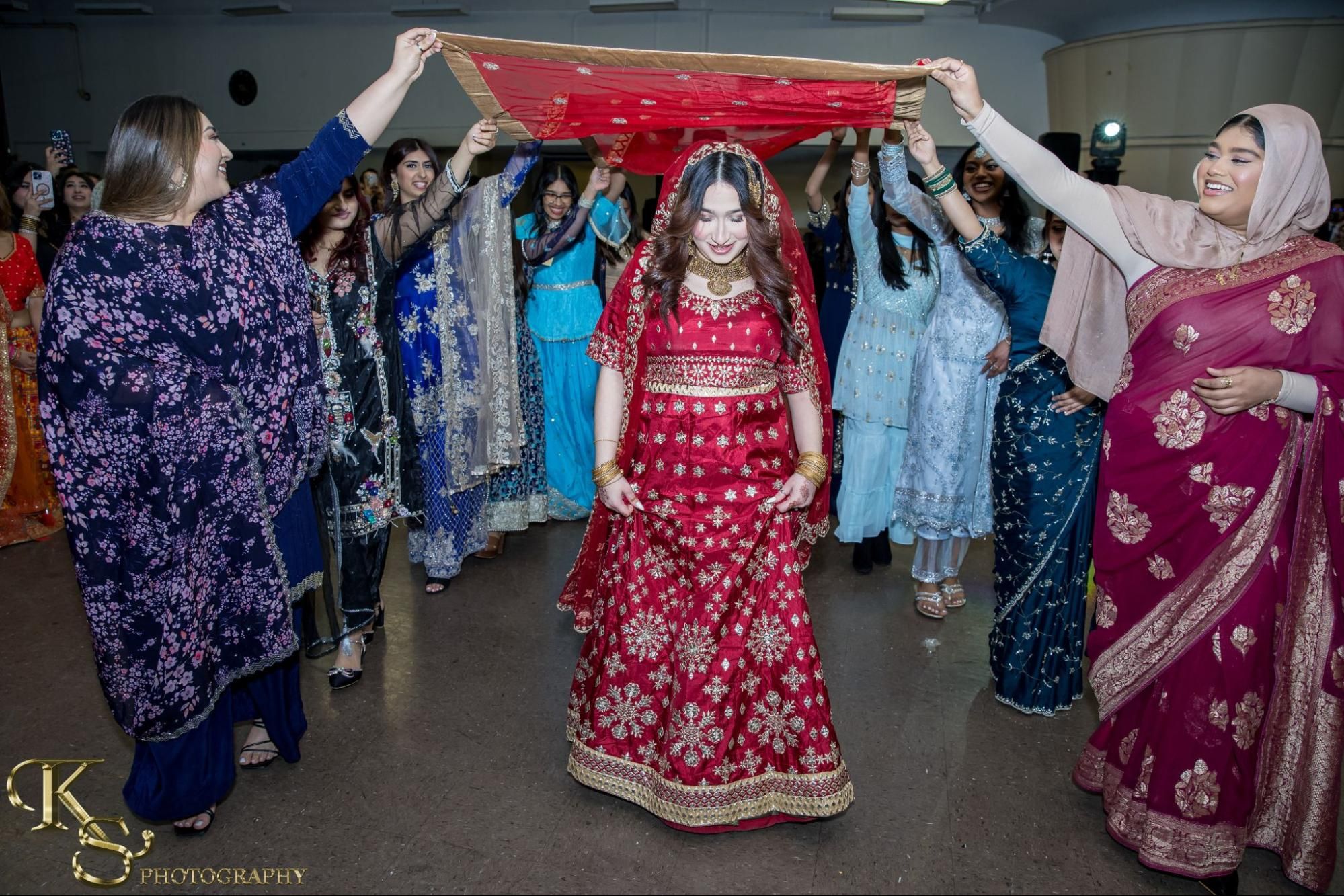Student walks underneath canopy created by other students holding fabric.