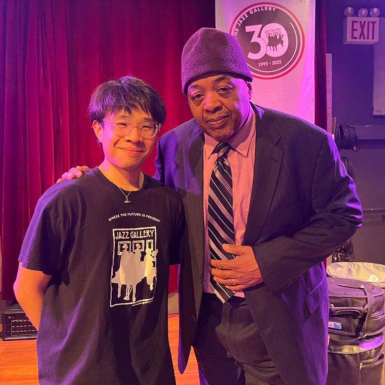 Student smiles for photo with Jazz musician at his internship.
