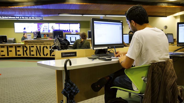 student at computer in new library