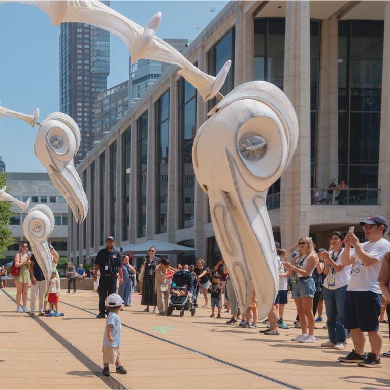 People admire large bird sculptures outside of Lincoln Center.