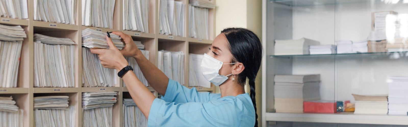 Medical worker retrieving files from archive.