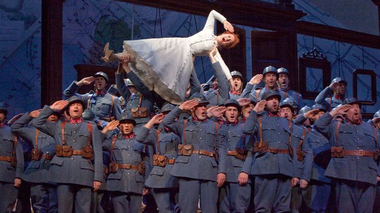 Opera singer being held on stage while she sings.