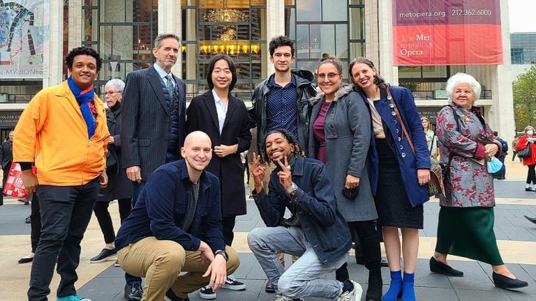 Met Student Ambassadors pose for a photo in front of the opera.
