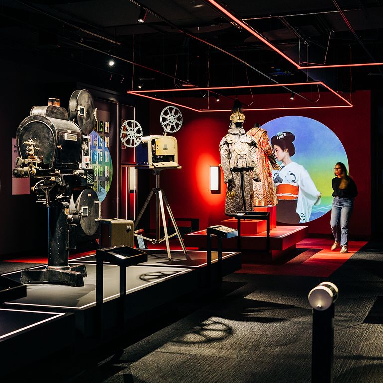 Exhibit at the Museum of the Moving Image showing the progression of film cameras and costume in the background.