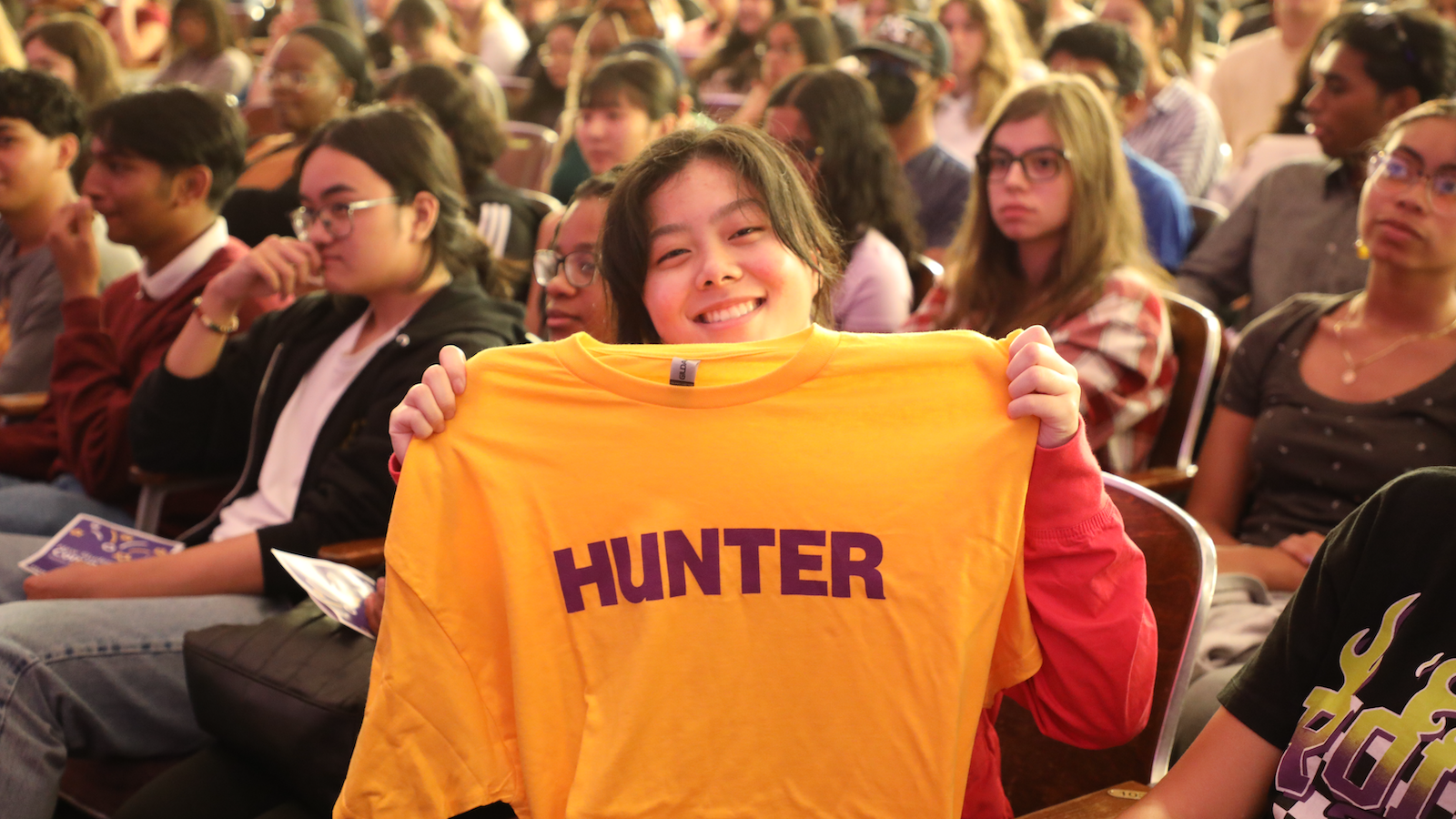 girl at convocation holding Hunter tshirt