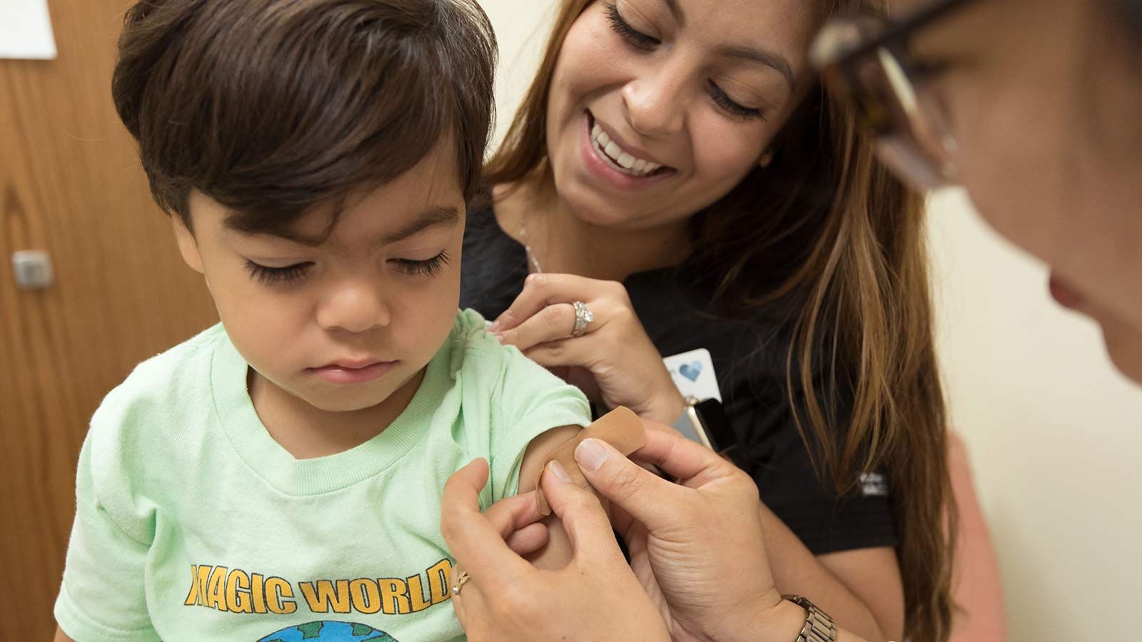 Nurse putting band aid on boy