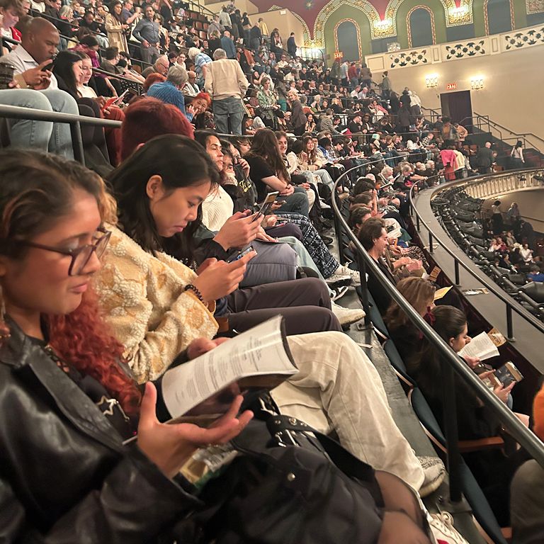Hunter students reading the program before a performance at New York City Center