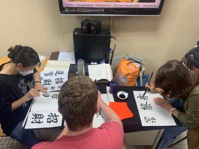 students practicing calligraphy together