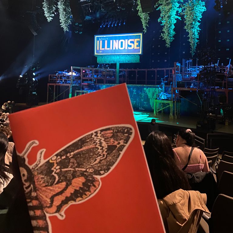 Student hold up program with a view of the stage behind it at Park Avenue Armory.