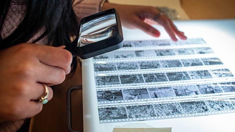 A person looking at film negatives