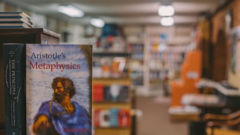 Image of library with a focus on Aristotle book