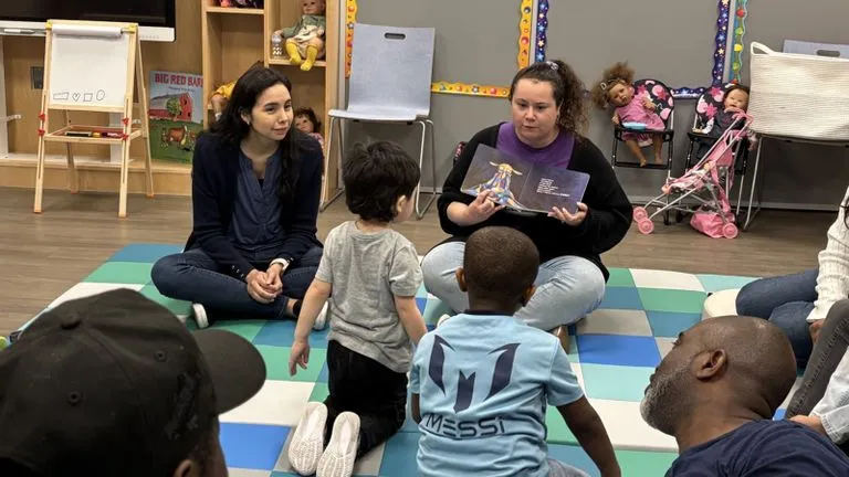 Students read aloud to children in the playgroup