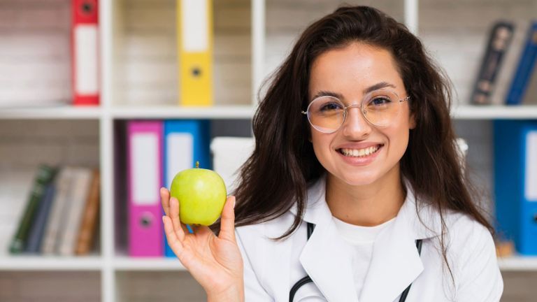 Nutrition specialist holding a green apple.