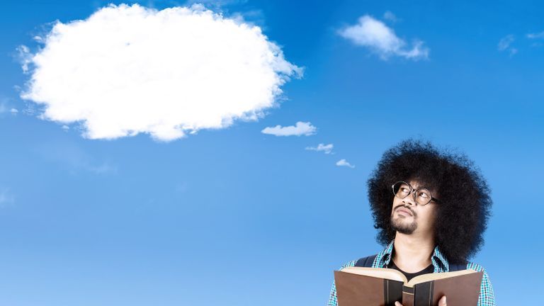 Afro student with a book and looking at a cloud which has formed into a speech bubble