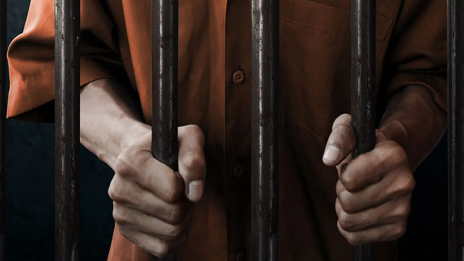 A person incarcerated behind bars.