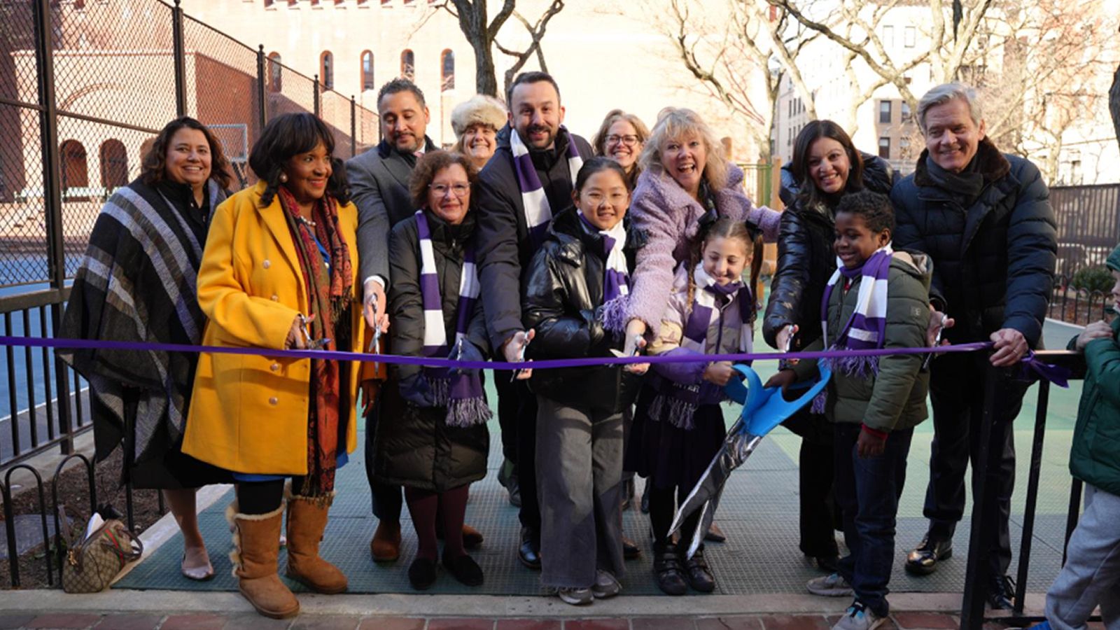 Students, Hunter officials, local officials, and guests cut the ribbon at the new Ron H. Brown Playground.
