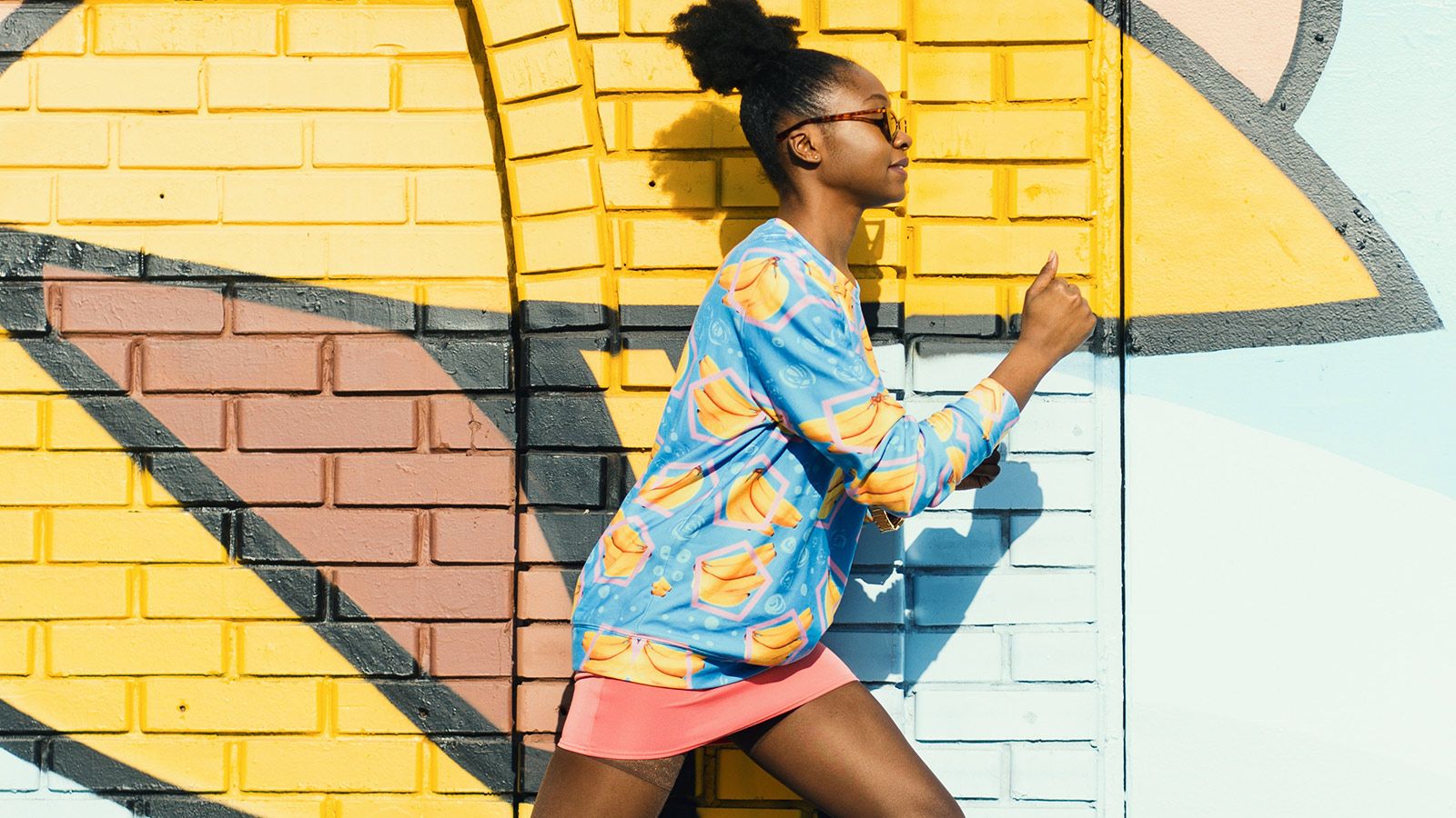 girl running in front of graffiti 