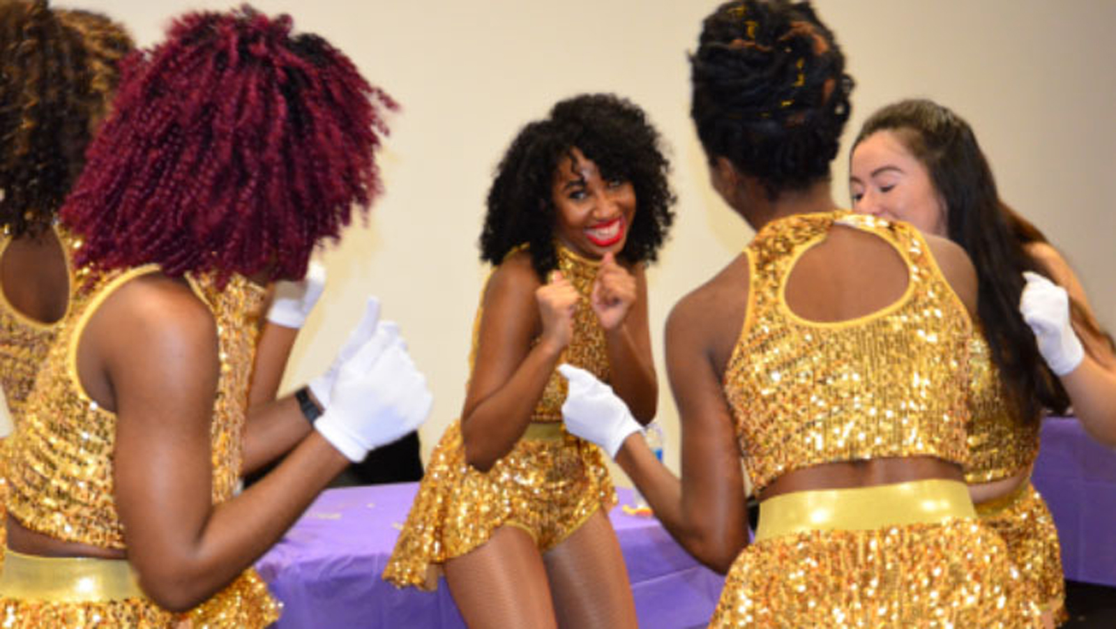 Photo of Spirit Squad members in gold sequin costumes