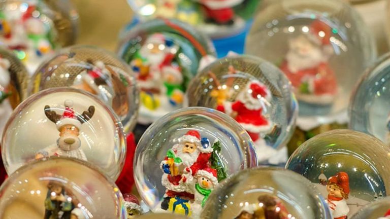 Photo of snow globes with a variety of items inside such as elves, reindeer, Santa