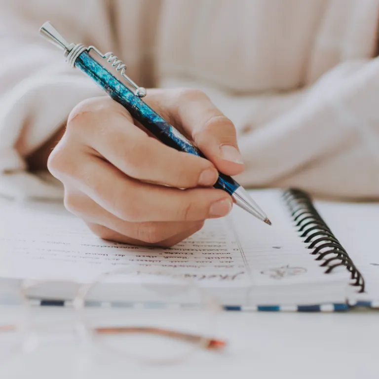 Someone writing in a notebook