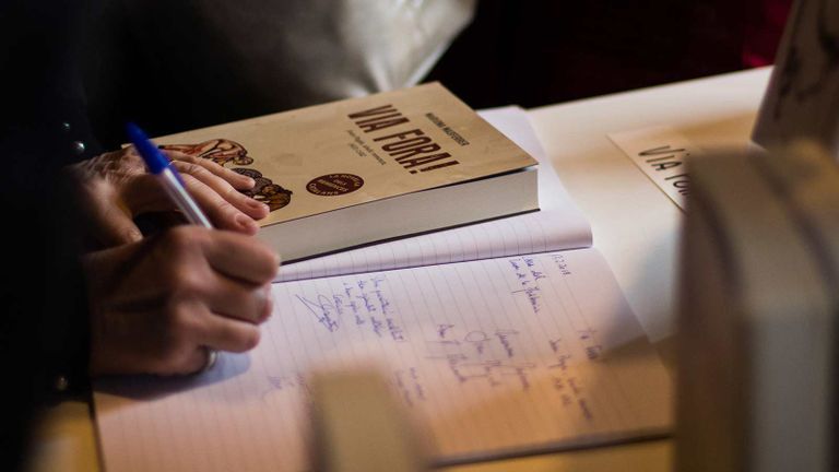Person writing in a book